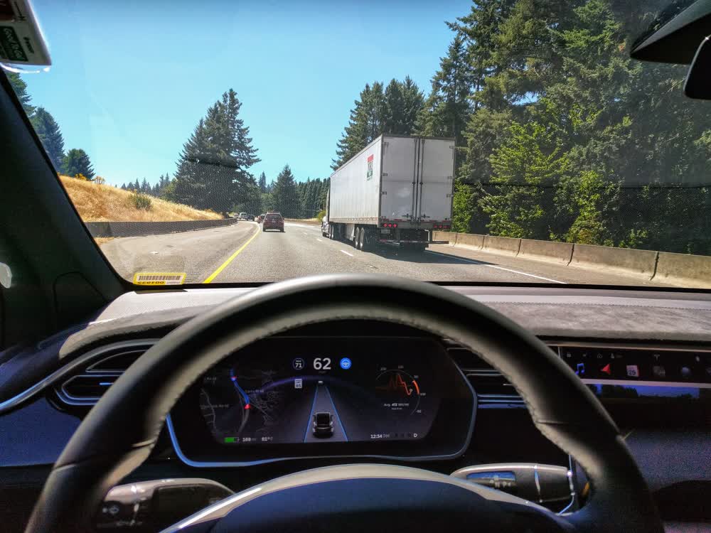 हाईवे पर एक Tesla, डैश पर Autopilot सड़क विज़ुअलाइज़ेशन के साथ